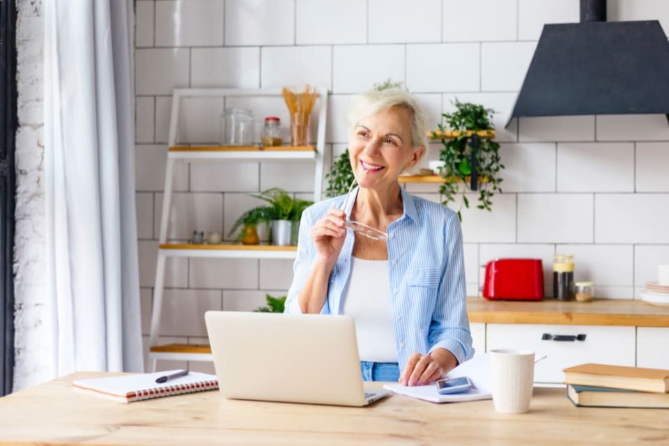 A senior woman at home calculating the costs of long-term care