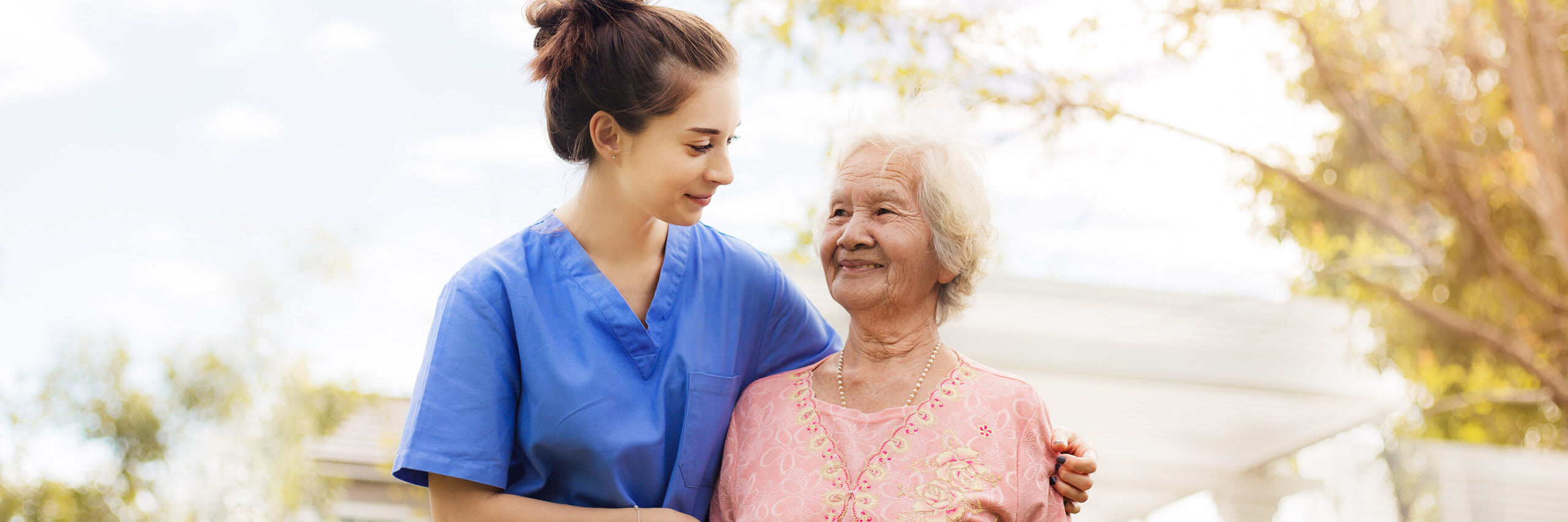 A senior and a caregiver smiling