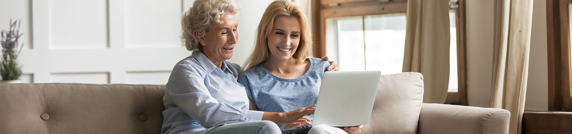 A woman and her senior loved one research on a laptop how to pay for home care